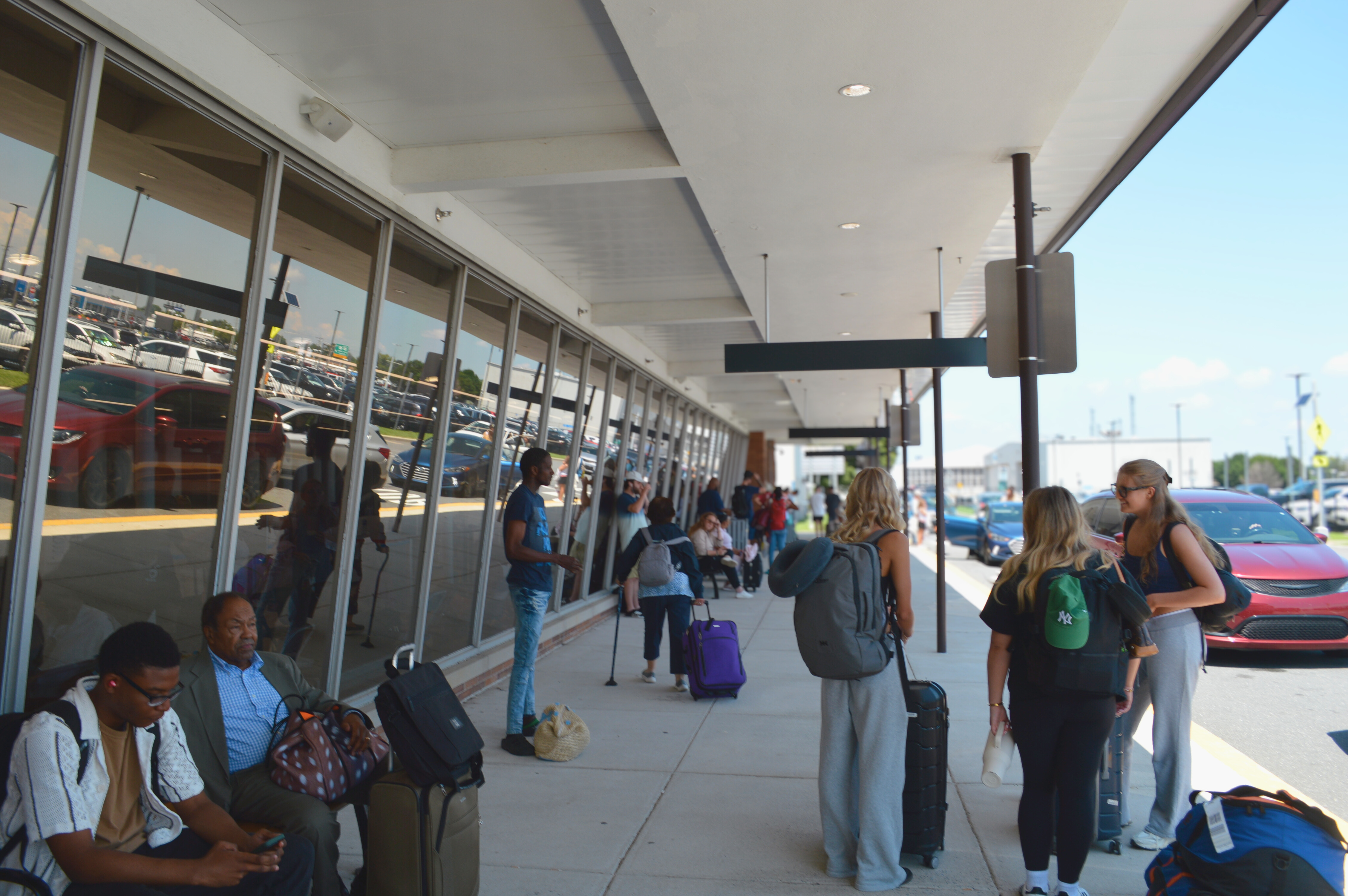 Passengers outside of ILG terminal at drop-off/pick-up area