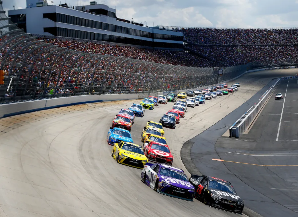 NASCAR drivers race around a bend at Dover Motor Speedway