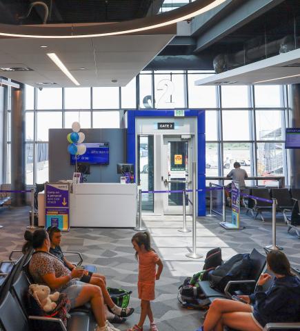 People wait to board their flight in the gate area of Wilmington Airport ILG